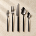 Chefcrest black PVD five-piece cutlery set on ivory background